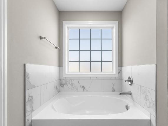 bathroom with plenty of natural light and a bath