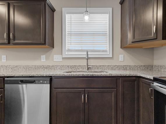 kitchen with a wealth of natural light, sink, stainless steel dishwasher, and dark brown cabinetry