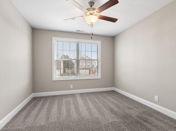 empty room with ceiling fan and carpet flooring