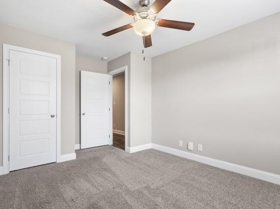 unfurnished bedroom with ceiling fan and carpet