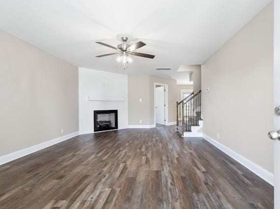 unfurnished living room featuring dark hardwood / wood-style floors and ceiling fan