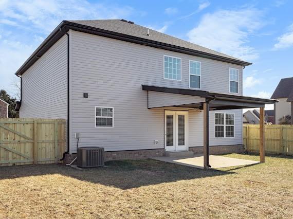 back of property with a yard, a patio area, and central air condition unit