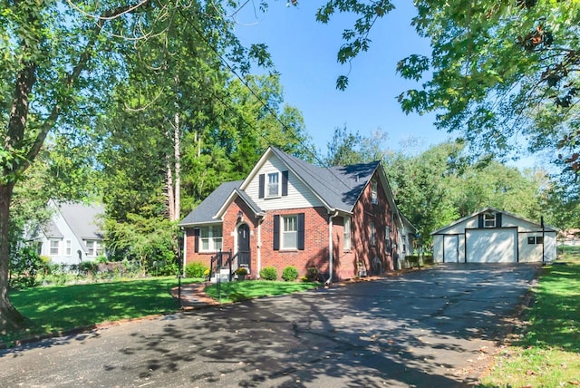 view of front of house featuring an outbuilding, a front yard, and a garage