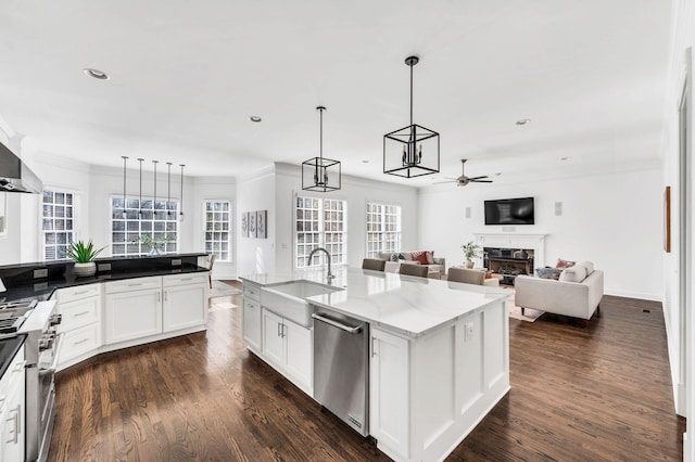 kitchen featuring white cabinetry, sink, light stone countertops, a kitchen island with sink, and appliances with stainless steel finishes