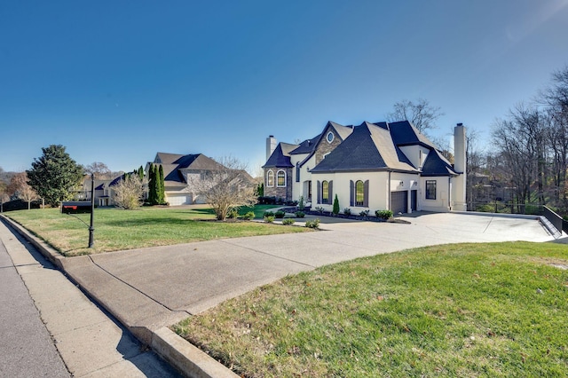 french country home with a front yard and a garage