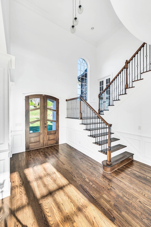 entrance foyer with a towering ceiling, french doors, and dark hardwood / wood-style flooring