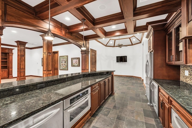 kitchen with dark stone countertops, ornate columns, tasteful backsplash, decorative light fixtures, and stainless steel appliances