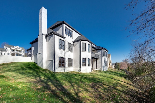 rear view of house featuring a lawn