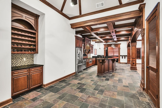 kitchen with backsplash, decorative columns, stainless steel fridge, crown molding, and a kitchen island