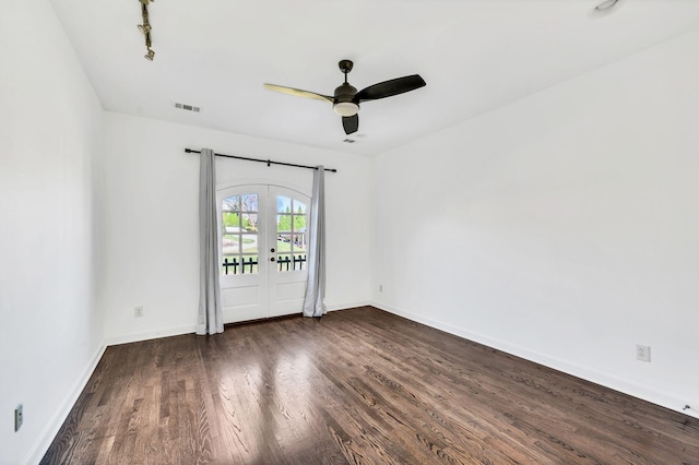 empty room featuring dark hardwood / wood-style floors, ceiling fan, and french doors