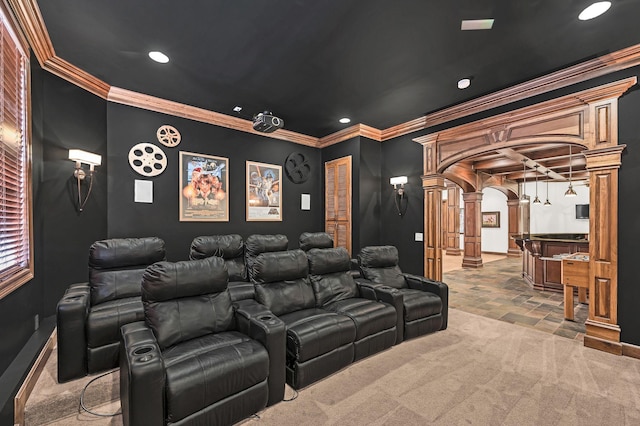 carpeted home theater featuring ornate columns and ornamental molding