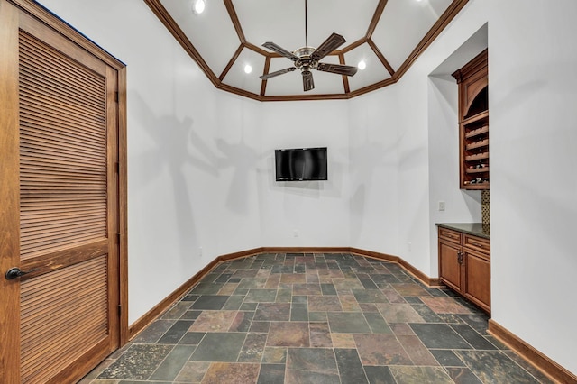 interior space with ceiling fan, vaulted ceiling, and ornamental molding