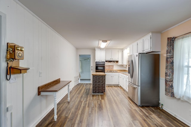 kitchen with wood counters, dark hardwood / wood-style flooring, ornamental molding, stainless steel appliances, and white cabinetry