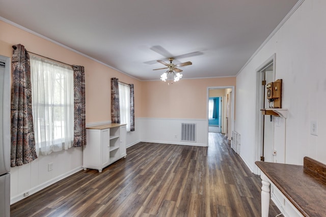 unfurnished living room featuring ceiling fan, dark hardwood / wood-style flooring, and ornamental molding