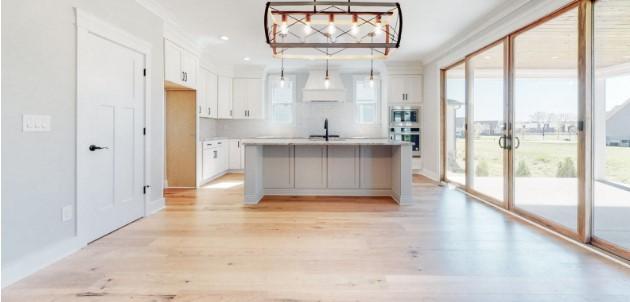 kitchen featuring a kitchen island with sink, light hardwood / wood-style flooring, white cabinets, and pendant lighting