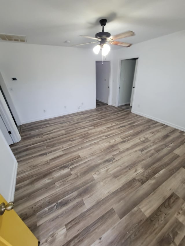 empty room featuring ceiling fan and dark wood-type flooring