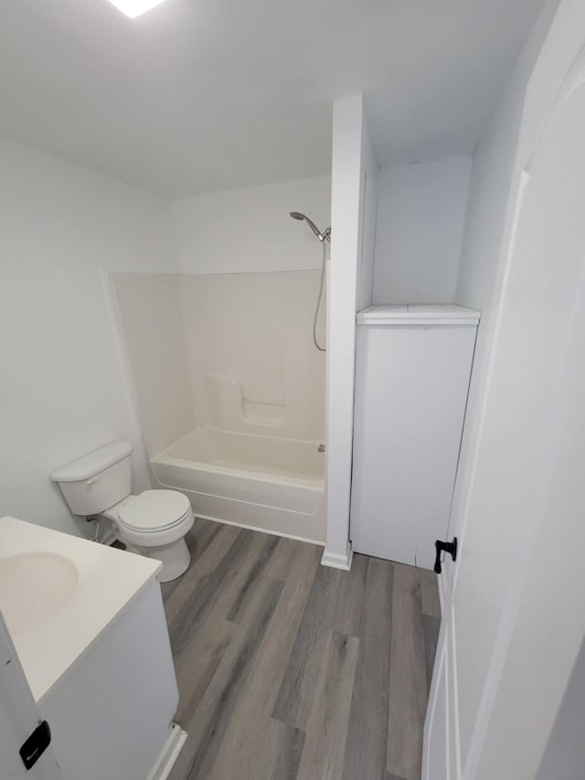 full bathroom featuring hardwood / wood-style floors, vanity, toilet, and tub / shower combination