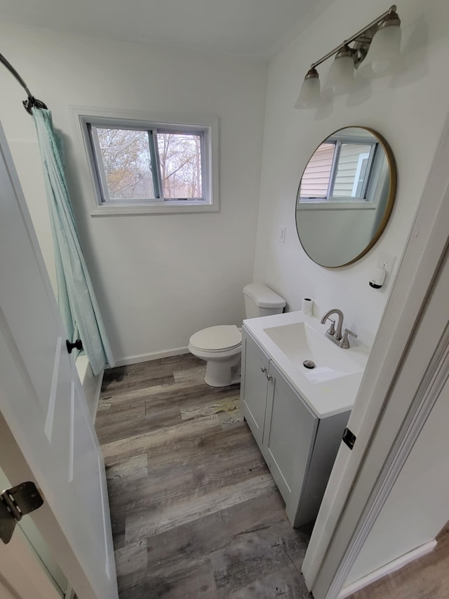 bathroom featuring vanity, hardwood / wood-style flooring, toilet, and plenty of natural light