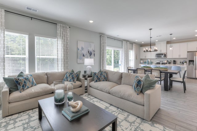 living room featuring an inviting chandelier and light hardwood / wood-style flooring