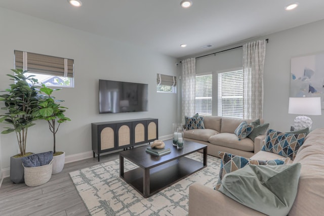 living room with plenty of natural light and light hardwood / wood-style flooring