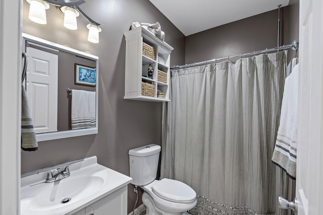 bathroom featuring vanity, toilet, and walk in shower