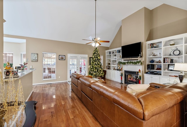 living room featuring french doors, light wood-type flooring, high vaulted ceiling, and ceiling fan