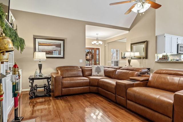 living room featuring ceiling fan with notable chandelier, light hardwood / wood-style floors, and crown molding