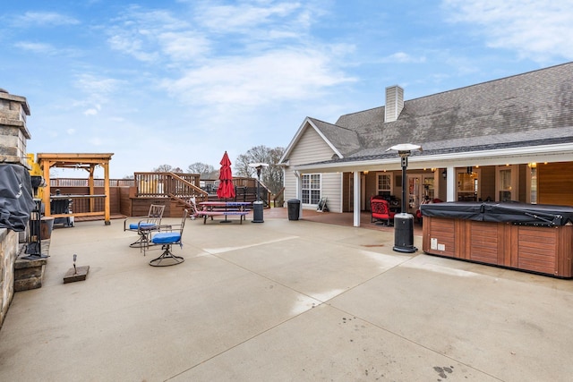 view of patio with a deck and a hot tub