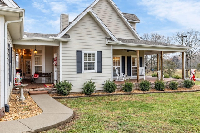 view of front of home with ceiling fan, a porch, and a front lawn