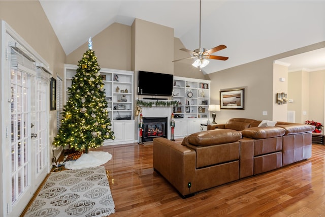 living room featuring hardwood / wood-style floors, ceiling fan, crown molding, and high vaulted ceiling