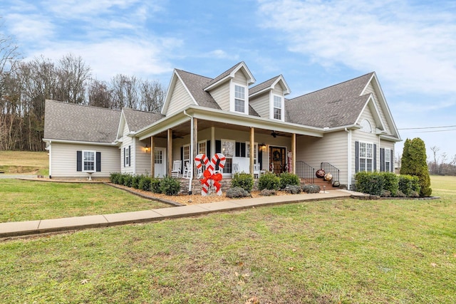 view of front facade featuring ceiling fan, covered porch, and a front yard