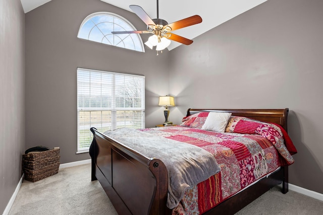 carpeted bedroom featuring multiple windows, high vaulted ceiling, and ceiling fan