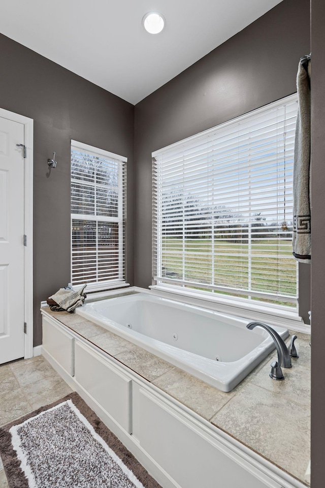 bathroom with tile patterned flooring, a tub to relax in, and plenty of natural light