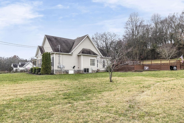 view of side of property featuring cooling unit, a lawn, and a deck