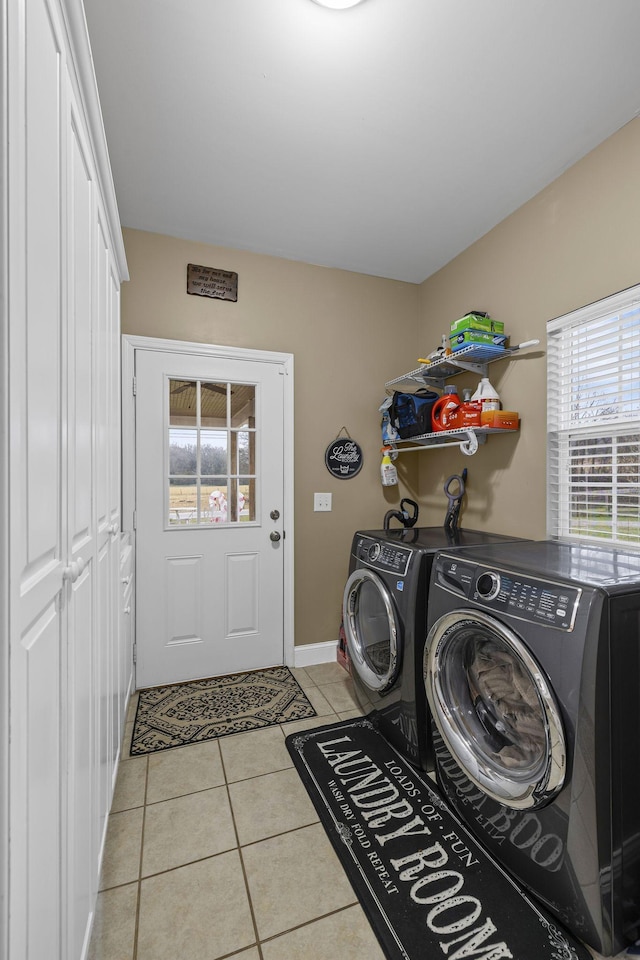 laundry room with laundry area, light tile patterned floors, baseboards, and separate washer and dryer