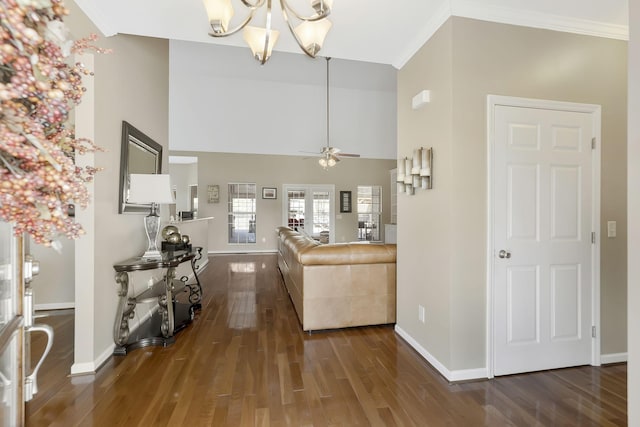 living room with ornamental molding, wood finished floors, a high ceiling, and baseboards