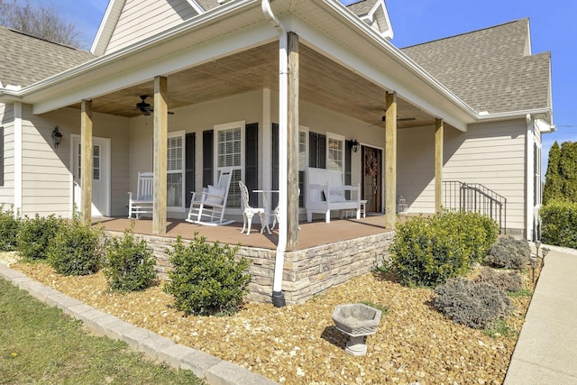 entrance to property with ceiling fan, a porch, and a shingled roof