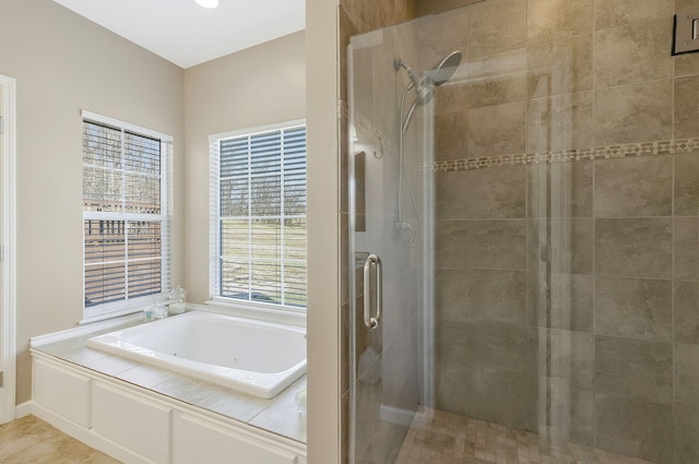 full bath featuring a shower stall and a tub with jets