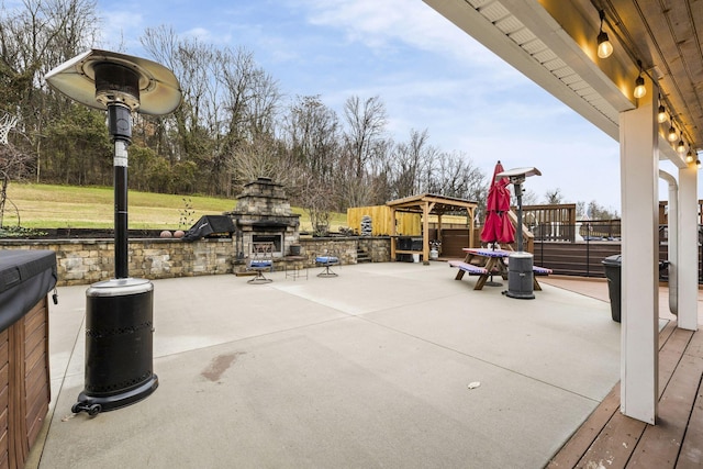 view of patio featuring an outdoor stone fireplace