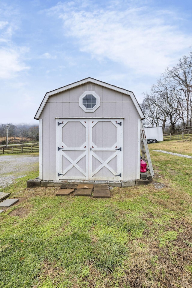 view of shed featuring a rural view and fence