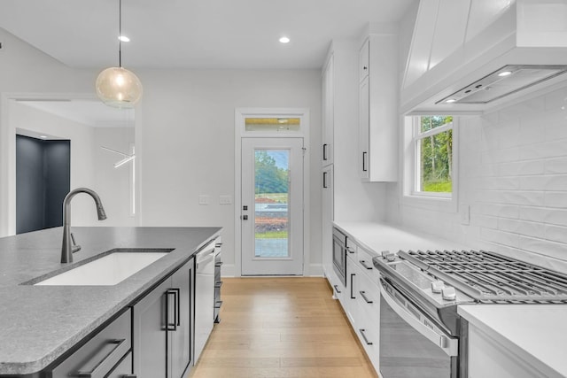 521 Matthew Miller Dr, Smyrna, TN 37167 - kitchen with appliances with stainless steel finishes, custom range hood, light wood-style floors, pendant lighting, and decorative backsplash