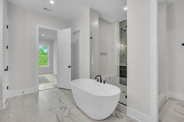 521 Matthew Miller Dr, Smyrna, TN 37167 - bathroom featuring marble look tiles, a freestanding tub, tiled shower, and recessed lighting