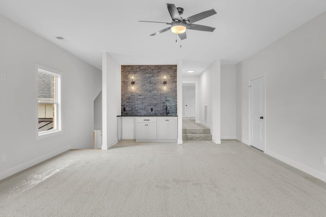 521 Matthew Miller Dr, Smyrna, TN 37167 - unfurnished living room with bar area, light carpet, and a ceiling fan