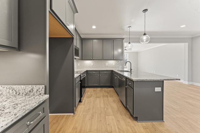 kitchen with light stone counters, stainless steel appliances, pendant lighting, gray cabinets, and light hardwood / wood-style floors
