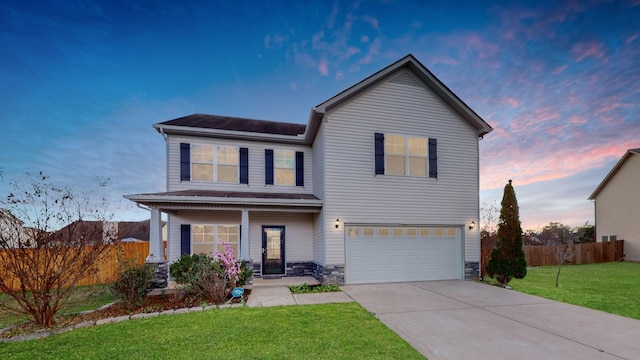 front facade featuring a lawn and a garage