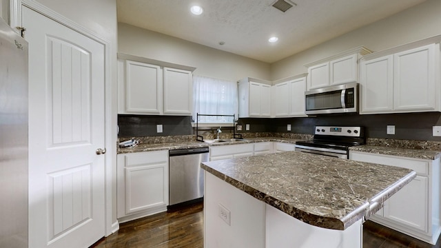 kitchen featuring a center island, sink, stainless steel appliances, dark hardwood / wood-style flooring, and white cabinets