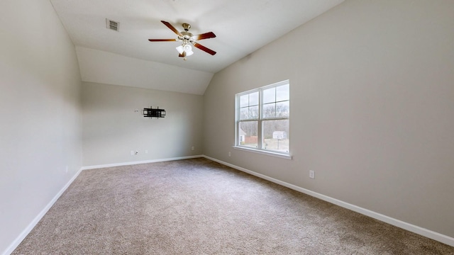 carpeted empty room featuring vaulted ceiling and ceiling fan