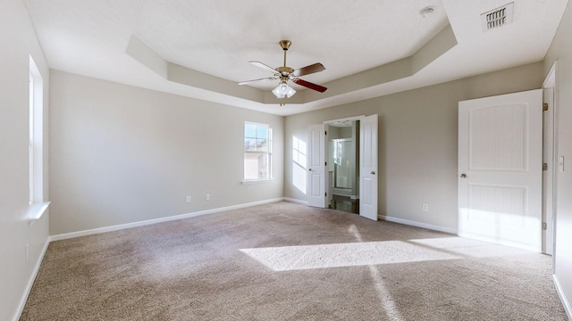 unfurnished bedroom with light carpet, a raised ceiling, and ceiling fan