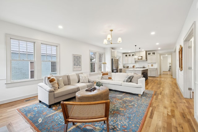 living room with an inviting chandelier and light hardwood / wood-style floors