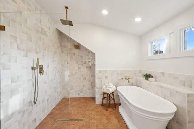 bathroom with shower with separate bathtub and tile walls